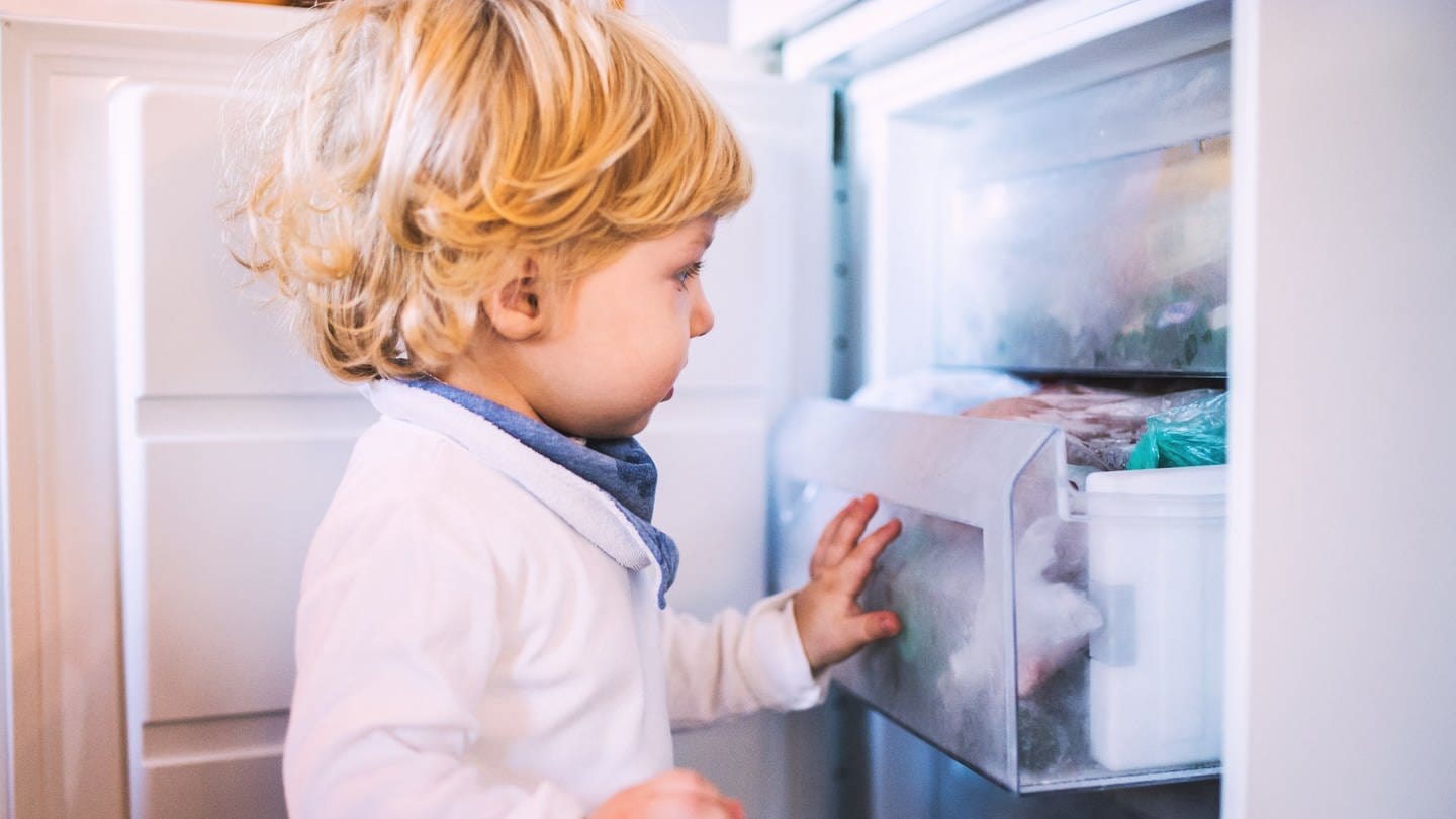 Kleines Kind steht vor Tiefkühlfach | Diese Lebensmittel nicht einfrieren oder im Gefrierfach oder Tiefkühler lagern. (Foto: Colourbox)