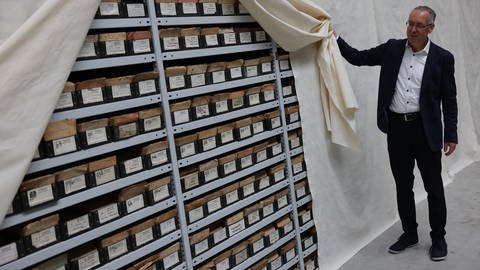 Manfred Wichmann, Sammlungsdirektor, zeigt im Depot des Hauses der Geschichte Karteikästen mit Angaben zu vermissten Personen aus dem 2. Weltkrieg.
