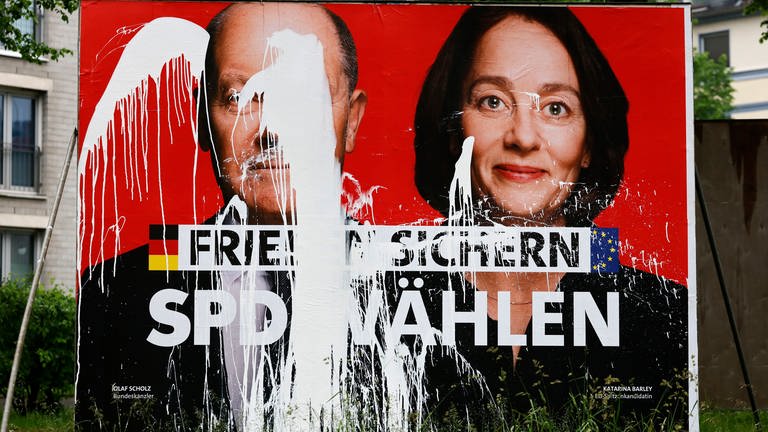 Plakat-Vandalismus in Köln: Ein SPD-Wahlplakat zur Europawahl 2024 mit den Portraits von Olaf Scholz und Katarina Barley und der Aufschrift 'Frieden sichern - SPD wählen' ist mit weißer Farbe verunstaltet worden. Politiker Schulz fordert ganze Härte des Gesetzes.