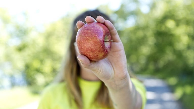 Frau mit Apfel (Foto: IMAGO, Westend61)