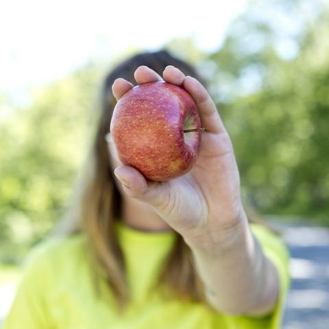 Frau mit Apfel (Foto: IMAGO, Westend61)