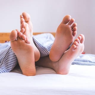 Keine Lust auf Sex in der Beziehung - wie wir wieder mehr Sex haben. Symbolbild: Füße unter Decke (Foto: picture-alliance / Reportdienste, picture alliance / Zoonar | Patrick Daxenbichler)