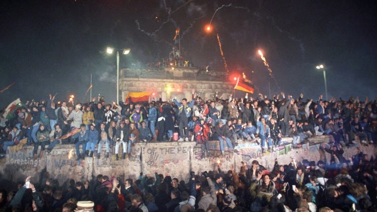 Mehrere hunderttausend Menschen aus Ost und West feiern am 31.12.1989 zum ersten Mal seit dem Bau der Berliner Mauer ausgelassen ein gesamtdeutsches Silvester am Brandenburger Tor. Berlin, Deutschland