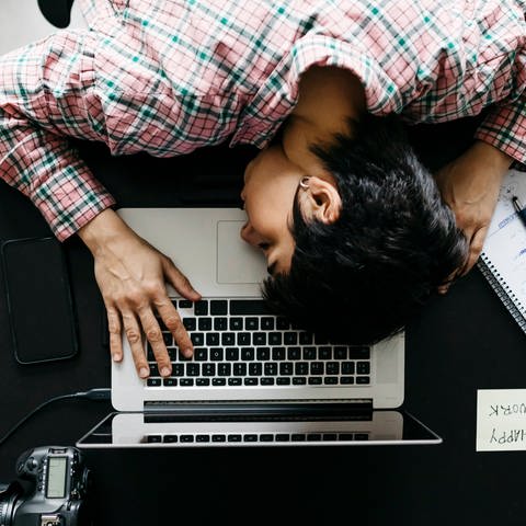 Frau beugt sich schlafend über eine Computertastatur (Foto: imago images, Westend61)