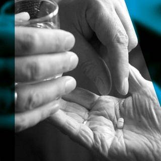 Die Hände einer Person mit Wasserglas sind sichtbar und legen eine Pille in die Hand einer älteren Person (Foto: ard-foto s2-intern/extern, Pressestelle, imago images/Becker&Bredel)