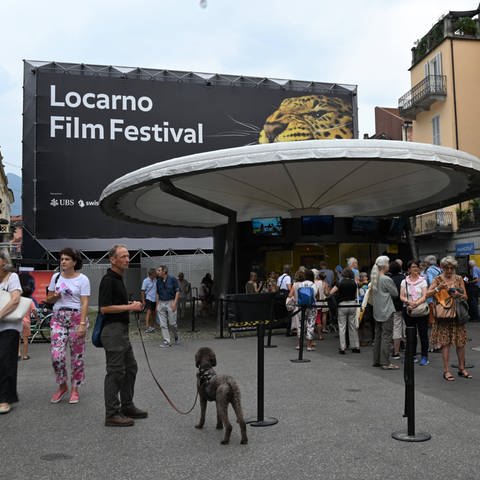 Menschen stehen in der Schlange vor dem Eingang zum Locarno Filmfestival (Foto: IMAGO, IMAGO / Independent Photo Agency Int. / /xipa-agency.net / Nick Zonna IPA_IPA39531842)