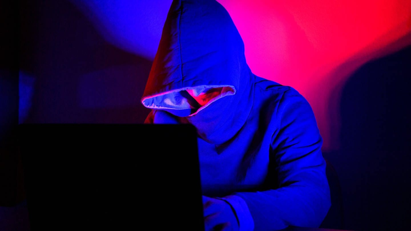 Mönche - Cyberkriminalität, Ein Mann mit Kapuzenpullover sitzt vor einem Laptop. (Foto: IMAGO, Kirchner-Media)