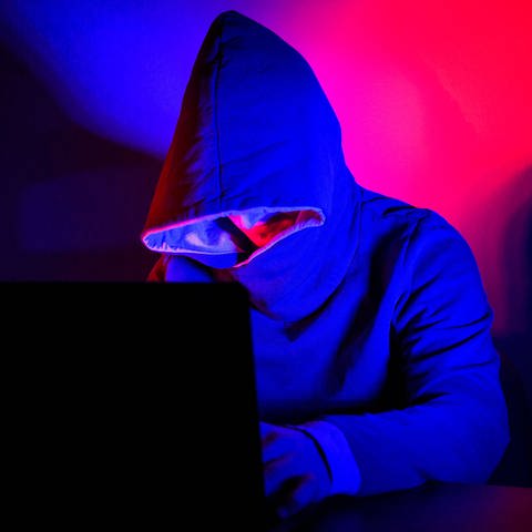 Mönche - Cyberkriminalität, Ein Mann mit Kapuzenpullover sitzt vor einem Laptop.  (Foto: IMAGO, Kirchner-Media)