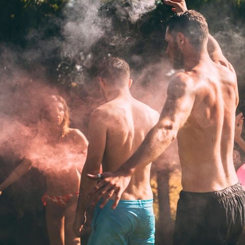tanzende Menschen zünden Rauchfackel an (Foto: IMAGO, Addictive stock / Eduardo Huelin)
