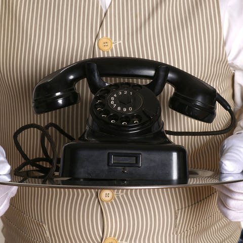 Butler bringt ein altes Telefon  (Foto: IMAGO, CHROMORANGE)