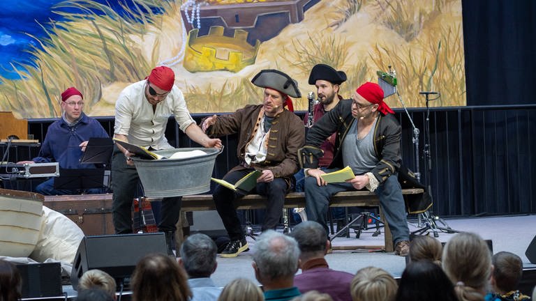 Drei Schauspieler mit Musikern im Hintergrund beim Live-Kinderhörspiel "Seeräuber-Moses" (Foto: SWR, Uwe Riehm)