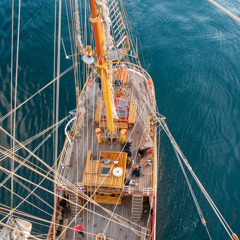 Blick vom Krähennest hinunter auf ein Segelboot (Foto: unsplash/Tobias Fischer)