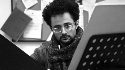 Ein junger Mann blickt konzentriert auf ein Notenblatt (Foto: SWR, Raffael Nassif - ensemble cross.art 2013)
