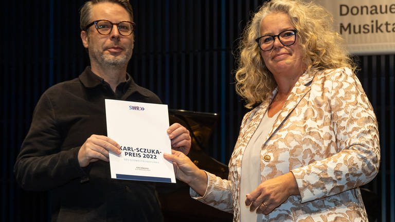 Karl-Sczuka-Preisverleihung 2022: Anke Mai übergibt die Urkunde an Jan Jelinek (Foto: SWR, Ralf Brunner)