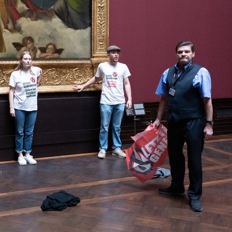 Zwei Umweltaktivisten der Gruppe «Letzte Generation» stehen in der Gemäldegalerie Alte Meister an dem Gemälde «Sixtinische Madonna» (Foto: picture-alliance / Reportdienste, Sebastian Kahnert)
