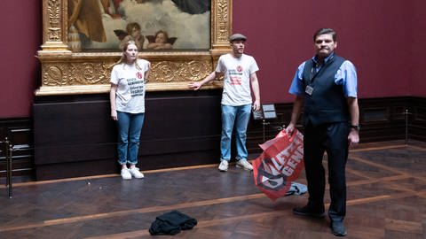 Zwei Umweltaktivisten der Gruppe «Letzte Generation» stehen in der Gemäldegalerie Alte Meister an dem Gemälde «Sixtinische Madonna» (Foto: picture-alliance / Reportdienste, Sebastian Kahnert)