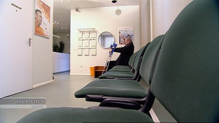 Ein Mann mit Krücken sitzt allein in einem großen Wartezimmer (Foto: SWR, SWR, Report Mainz)