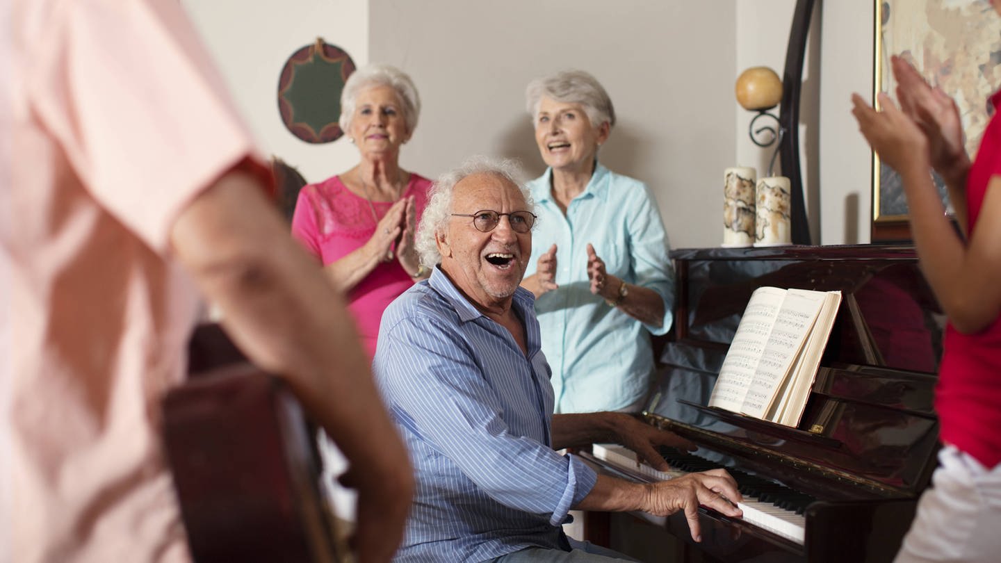 Seniorinnen und Senioren musizieren in einem Altenheim.