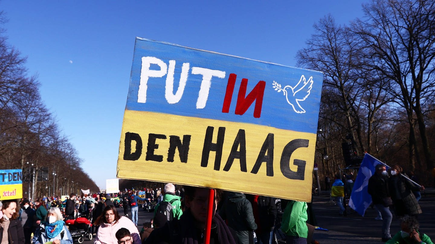 Ein Berliner Demonstrant hält ein Schild mit der Aufschrift 