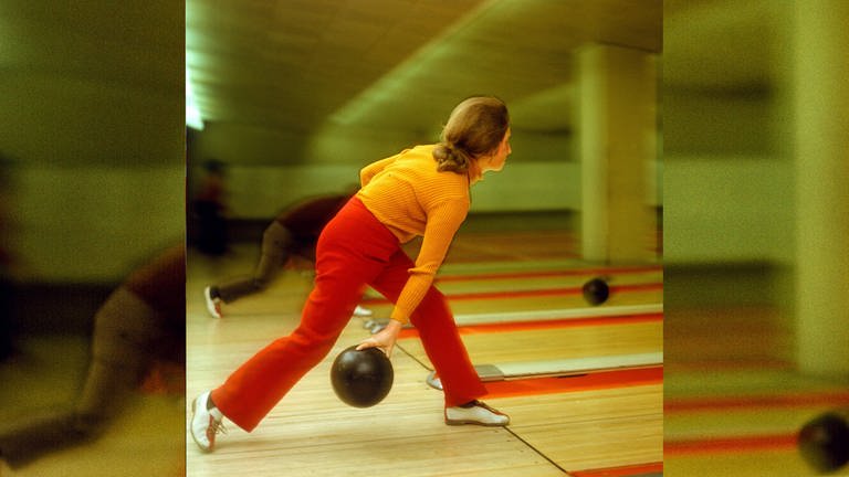 Eine Frau in frabenfroher Kleidung der 70er Jahre beim Bowling. (Foto: IMAGO, imago/Werner Schulze)