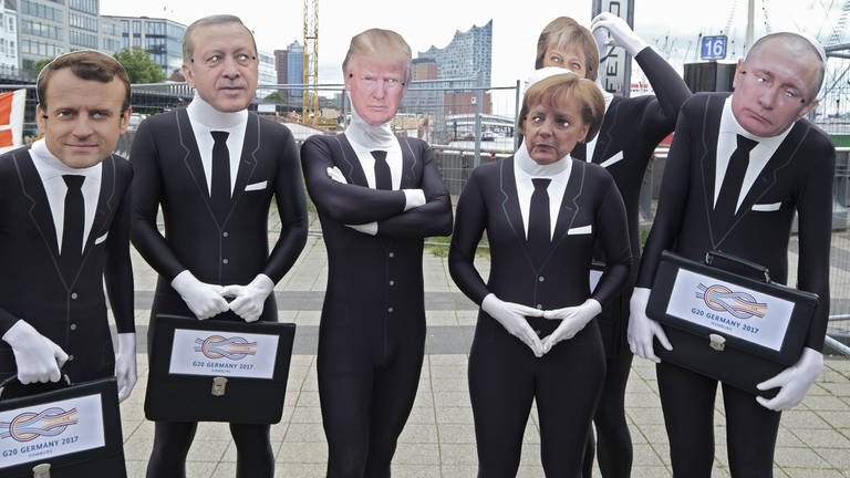 Attac-Aktivistin posieren mit Masken als G20-Politiker (Foto: IMAGO, Foto: epd)