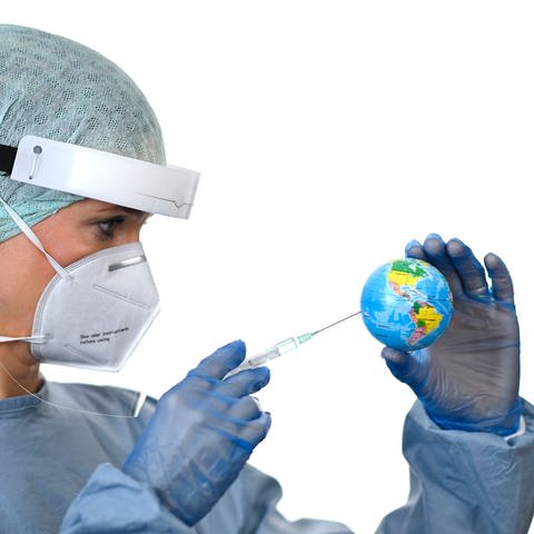 Eine Ärztin mit Spritze, die eine kleine Weltkugel impft (Foto: IMAGO, imago images / Michael Weber)