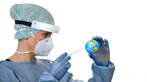 Eine Ärztin mit Spritze, die eine kleine Weltkugel impft (Foto: IMAGO, imago images / Michael Weber)