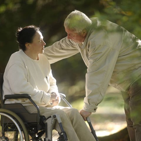 Symbolbild - Mann spricht mit seiner Frau im Rollstuhl  (Foto: IMAGO, imagebroker)