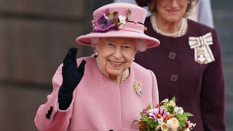 Die britische Königin Elizabeth II. hält einen Blumenstrauß in der Hand und winkt (Foto: dpa Bildfunk, picture alliance/dpa/PA Wire | Jacob King)