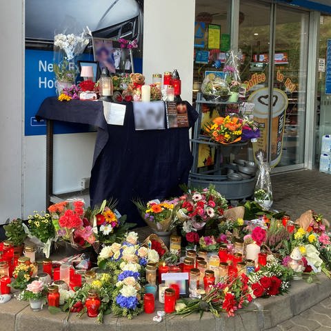 Blumen und Kerzen sind vor einer Tankstelle aufgestellt.  (Foto: dpa Bildfunk, picture alliance/dpa | Birgit Reichert)