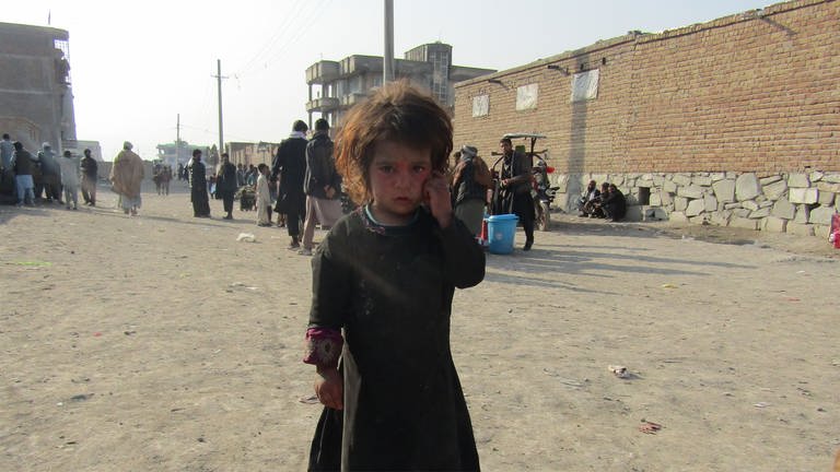 Bild eines Kindes auf einer Straße. Im Hintergrund Menschen. 80 Prozent der Binnenflüchtlinge sind Frauen und Kinder. (Foto: Afghanischer Frauenverein e.V.)