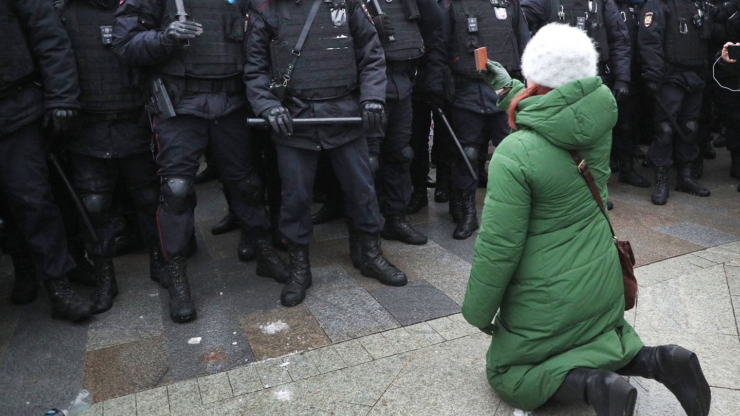 Russland 2021: Eine Frau kniet während einer nicht autorisierten Kundgebung  vor Bereitschaftspolizisten auf dem Puschkinskaja-Platz (Foto: IMAGO, Gavriil Grigorov/TASS)