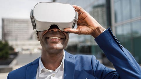 Happy businessman wearing virtual reality simulator model released. (Foto: IMAGO, IMAGO / Westend61)