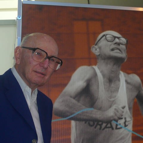 Ladany vor seinem Poster von den Olympischen Spielen 1972 in München, an denen er als Geher teilnahm. (Foto: Igal Avidan - NICHT MEHR VERWENDEN)