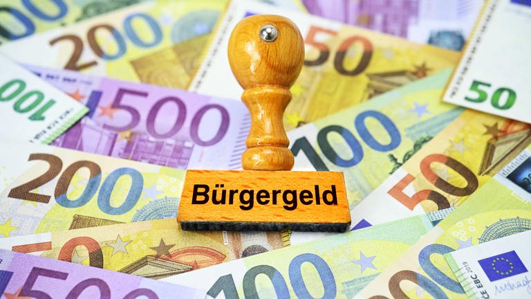 Stempel mit Aufschrift Bürgergeld auf Geldscheinen (Foto: picture-alliance / Reportdienste, picture alliance / CHROMORANGE | Christian Ohde)