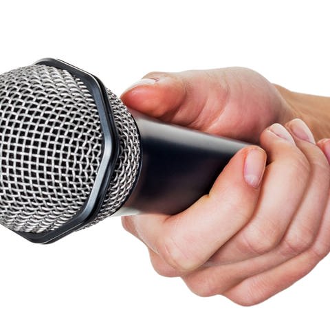 Eine Frau hält ein Mikrofon in der Hand. Interview und Meinungsumfrage Symbolfoto (Foto: IMAGO, McPhoto)