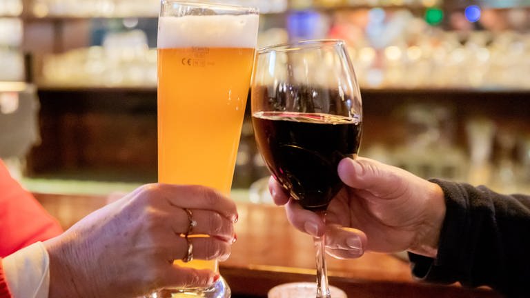 Zwei Gäste stoßen in einer Berliner Gaststätte mit Wein und Bier an. (Foto: picture-alliance / Reportdienste, Christoph Soeder)
