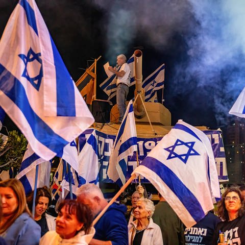 Demonstranten in Israel schwenken bei einer Demonstration die israelische Flagge (Foto: IMAGO, IMAGO / ZUMA Wire / MatanxGolan)