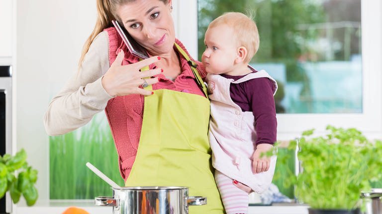 RECORD DATE NOT STATED Working mom being stressed by housework, cooking, preparing, job, mobile phone and kids, model released, (Foto: IMAGO, IMAGO / YAY Images 36368904.jpg)