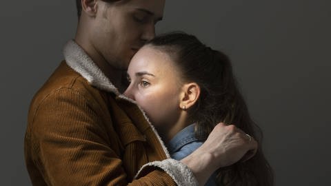Ein Mann hält eine Frau im Arm und tröstet sie (Foto: IMAGO, Imago)