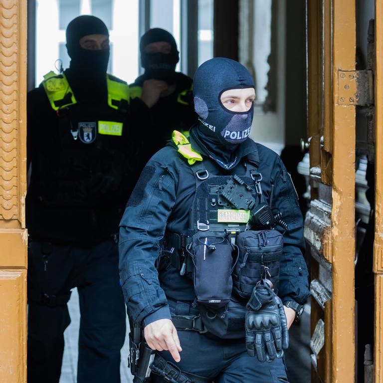 Polizisten kommen bei einer Hausdurchsuchung in Berlin-Kreuzberg aus einem Gebäude. (Foto: dpa Bildfunk, picture alliance/dpa | Christoph Soeder)