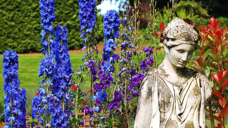 Göttinnenstatue in frühlingshaftem Blumenbeet (Foto: IMAGO, IMAGO / YAY Images)