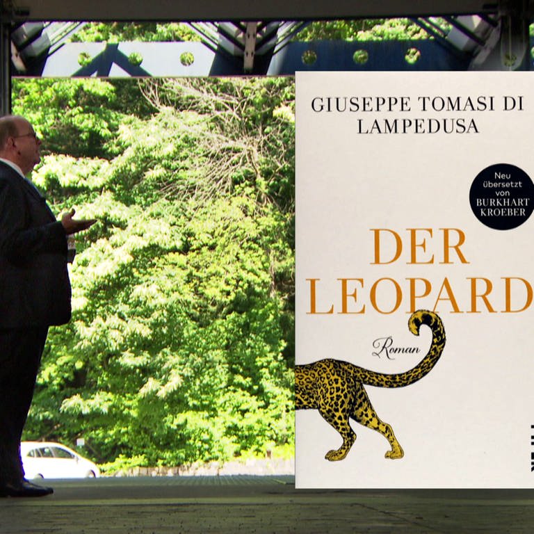 Moderator Denis Scheck steht neben Roman von Giuseppe Tomasi di Lampedusa mit dem Titel „Der Leopard“ (Foto: SWR)