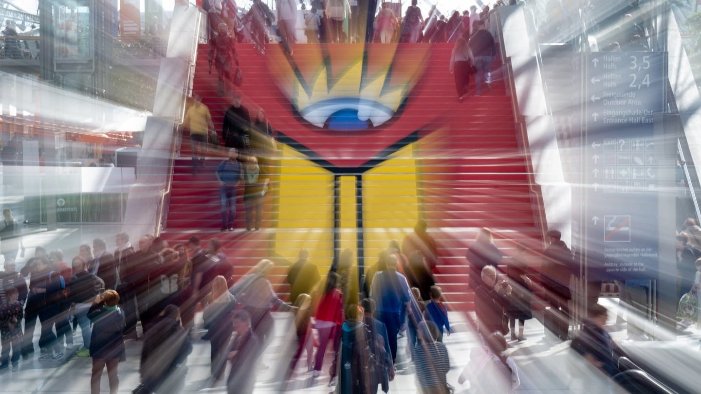 Menschen gehen eine Treppe mit Logo der Leipziger Buchmesse hinauf (Foto: dpa Bildfunk, Picture Alliance)