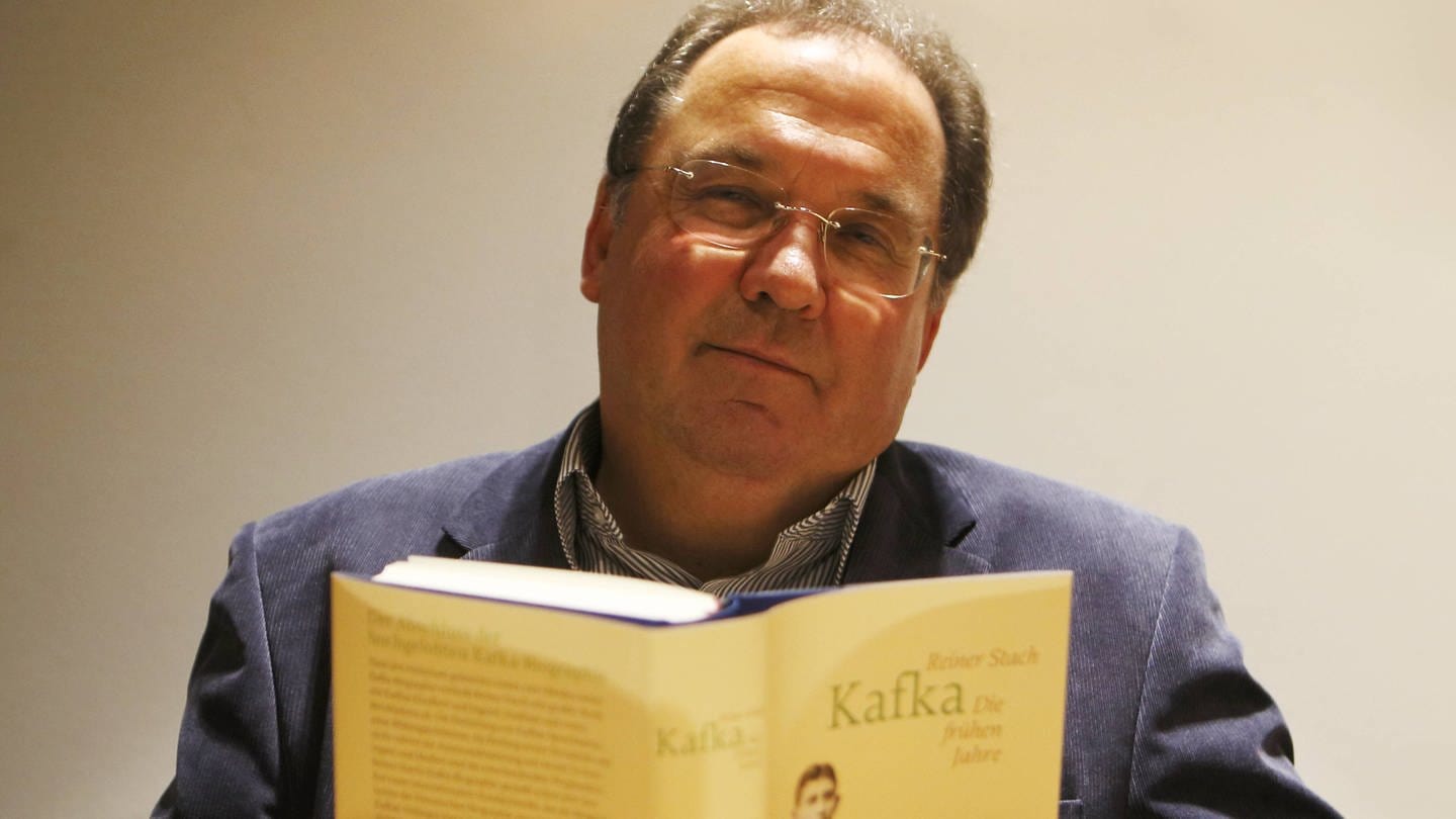 Der Kafka-Biograf Rainer Stach mit seinem Kafka-Buch (Foto: IMAGO, Gerhard Leber)