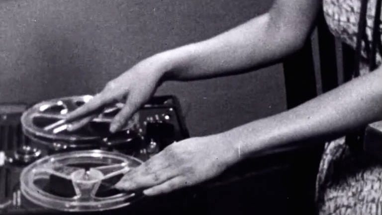 Schwarz-weiß Bild: Frauenhände bedienen ein Tonbandgerät (Foto: picture-alliance / Reportdienste, picture alliance / Everett Collection | Courtesy Everett Collection)
