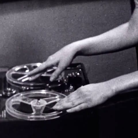 Schwarz-weiß Bild: Frauenhände bedienen ein Tonbandgerät (Foto: picture-alliance / Reportdienste, picture alliance / Everett Collection | Courtesy Everett Collection)