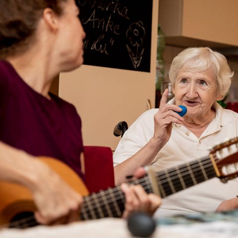 Musiktherapeutin singt mit Bewohnerin bei einer Gruppen-Musiktherapie-Stunde (Foto: dpa Bildfunk, picture alliance/dpa | Christoph Soeder)