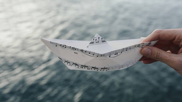 Ein Papierschiff aus Noten (Foto: IMAGO, IMAGO / Westend61)