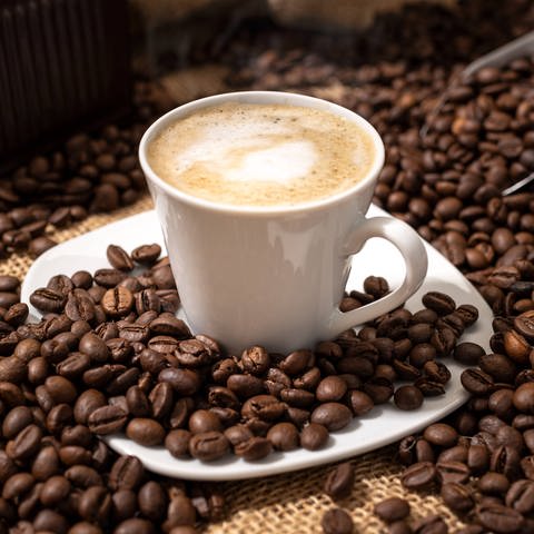 Cappuccino und geröstete Kaffeebohnen (Foto: IMAGO, IMAGO / Zoonar)